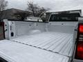 A 2021 Chevrolet Silverado 3500HD truck bed with a white interior showing a smooth surface and a wheel well on one side