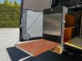 A 2017 Mercedes-Benz Sprinter with a rear fold-out wooden platform and a metal storage compartment featuring a diamond plate design