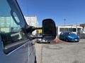 A blue 2008 Ford E-350 van is parked with its side mirror prominently in view