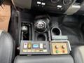 Close-up of the gear shifter and control panel in a 2011 Dodge Ram 5500 with multiple buttons switches and a manual transmission gear knob