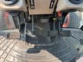 Close-up of the foot pedals and control levers in the driver's area of a 2010 Kubota M6040 tractor