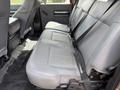 The image shows the interior of a 2013 Ford F-550 with a spacious seating area featuring gray cloth seats and seat belts in place