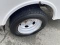 A close-up view of a black tire mounted on a silver rim from a 2015 Ford F-550 showing tread pattern and lug nuts