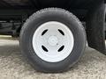 A close-up view of a white steel wheel and tire from a 2019 Ford Econoline showing the tread pattern and wheel design