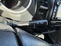 A close-up view of the control lever inside a 2015 Toyota Tacoma with symbols for windshield wipers and headlights