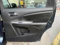 The interior door panel of a 2013 Dodge Journey featuring a soft-touch surface and a chrome door handle