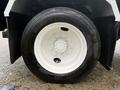 Close-up of a white tire on a 2019 Freightliner M2 featuring a silver rim with multiple bolts and a Michelin branding on the sidewall