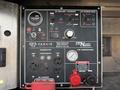 Control panel of a 2024 Ford F-550 featuring various dials and switches for a DC welder charger and air compressor along with indicator lights and a power connection