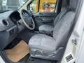 Interior of a 2010 Ford Transit Connect showing two front seats with fabric upholstery and a steering wheel visible