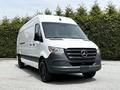A 2023 Mercedes-Benz Sprinter van with a sleek white exterior and black accents in the front