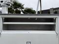 A 2012 Ford F-450 SD with an open compartment featuring two shelves supported by chains
