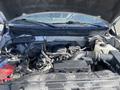 A 2012 Ford F-150 engine bay showing various components such as the battery intake manifold and hoses with visible dirt and dust on the surfaces