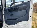 Door panel of a 2006 Hino 268 featuring a dark gray armrest and handle with controls for window adjustment and a textured surface