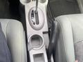 A center console of a 2007 Chrysler PT Cruiser featuring gear shift, cup holder, and a textured surface