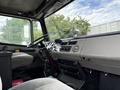 Interior view of a 1998 Freightliner FL80 showing the steering wheel dashboard and seating with a fan mounted on the dashboard