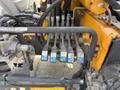 A close-up view of hydraulic control valves with colored levers on a 2011 International 4300 truck's chassis