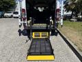 A 2016 RAM Promaster with a lowered wheelchair ramp extending from the rear doors of the vehicle
