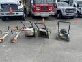 Three Honda Lawnboy mowers and two Stihl line trimmers are arranged in a line on the ground