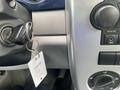 A 2007 Chrysler PT Cruiser ignition key is inserted into the ignition switch with a keychain and a small tag attached to it