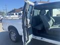 A 2014 Ford F-250 SD with an open driver side door and a spacious interior featuring gray fabric seating for multiple passengers