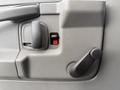 Interior door panel of a 2013 Chevrolet Express featuring a door handle a window crank and a red lock button