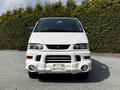 A white 2003 Mitsubishi 7 Passenger Van is shown from the front featuring stylish headlights and a distinctive grille with a bold bumper design