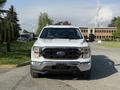 A front view of a white 2021 Ford F-150 showcasing its grille headlights and bumper design