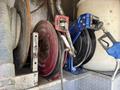 A 2009 International 7500 with two hose reels one red and one blue attached to a metal frame alongside a fuel nozzle