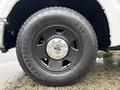 Close-up of a black wheel and tire from a 2008 Ford F-250 SD featuring a chrome hubcap and the Firestone Transforce A/T tire tread pattern