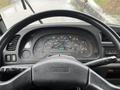 Dashboard of a 2006 GMC F7B042 showing gauges and controls with illuminated warning lights and a steering wheel in the foreground