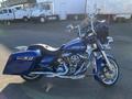 A 2017 Harley-Davidson FLHXS in blue with chrome accents featuring a touring design a large windshield and a comfortable two-tone seat