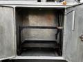 An empty metal storage compartment of a 2016 Ford F-550 with a black metal frame structure inside