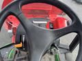 Steering wheel of a 2014 John Deere 1585 Terrain Cut with controls and dashboard visible