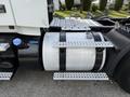 A 2012 Volvo VNL truck featuring a large cylindrical fuel tank secured with metal straps and safety steps on both sides