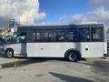 A 2018 Chevrolet Express bus with a gray and white exterior featuring large windows and a side entry door