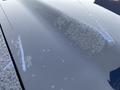 Close-up of a dark blue hood of a 2011 GMC Sierra 3500HD showing water spots and soap residue