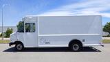 A 2011 Ford Econoline cargo van with a white exterior parked in a lot with an empty side view and no visible windows on the cargo area