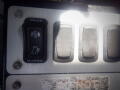 The image shows a panel with four push buttons including a toggle switch labeled for a tailgate with open and close options