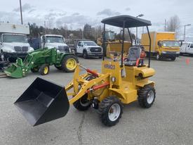 A yellow 2024 AGT KRW 23 Mini loader with a front bucket, four wheels, and a covered seat, designed for compact loading and lifting tasks