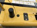 Close-up of control panel on a yellow 2014 Vermeer Corporation Sweep Stump Cutter featuring buttons and a lever