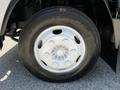 Close-up of a silver wheel with a circular tire labeled Commtercial T/A on a 2007 GMC W3500