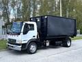 2009 Ford LCF 550 truck with a black waste container attached on the back and a white cab featuring orange lights and red reflective tape