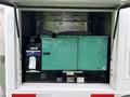 A 2011 Ford F-650 truck with an enclosed rear compartment containing a green Cummins Onan generator