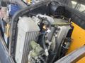 Close-up view of the engine compartment of a 2013 JCB 510-56 Loadall showing various components including a radiator and hydraulic parts