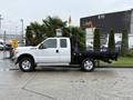 A 2016 Ford F-350 Super Duty pickup truck with a flatbed and palm trees on the back