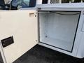 A white 2018 Ford F-350 with an open utility box door revealing an empty compartment inside