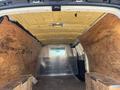 Interior of a 2012 Chevrolet Express van featuring wooden paneling and insulation on the ceiling with a single overhead light