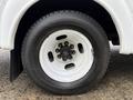 Close-up of a white wheel and tire from a 2015 Chevrolet Express with a five-bolt pattern on the rim and visible tread on the tire