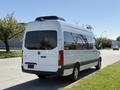 A 2023 Mercedes-Benz Sprinter van with a sleek white exterior and a high roof in a parked position