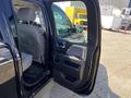 A black 2014 GMC Sierra 1500 with an open driver's side door revealing the interior and seating